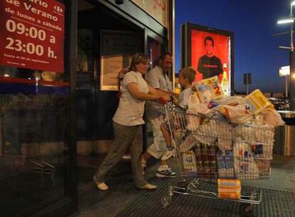Unos clientes abandonan el hipermercado de Carrefour en Alcobendas pasadas las diez de la noche.