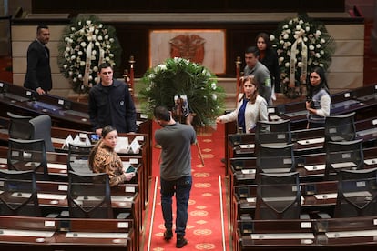 Un hombre carga una corona fúnebre este lunes en el Capitolio Nacional, horas antes del comienzo de la cámara ardiente del senador Uribe Turbay.