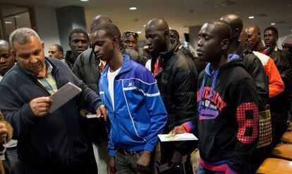 Unos inmigrantes se disponen a embarcar en Melialla rumbo a Málaga.