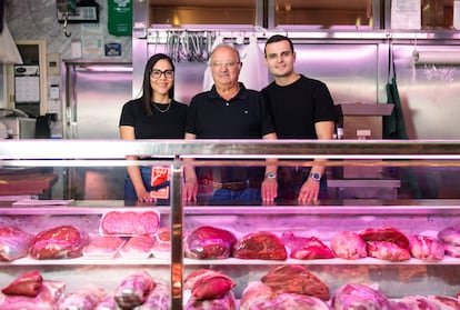 Estefanny Girón, Carlos García y Diego Salazar en la carnicería Los Hermanos García en el madrileño Mercado de Maravillas este jueves.