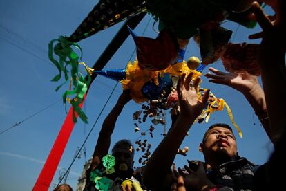 Un grupo de niños recogen frutas y dulces de una piñata rota durante las celebraciones del Día de Reyes en el centro de Ciudad de México.
