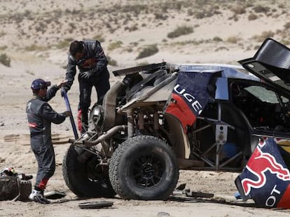 Loeb y Elena reparan el Peugeot.