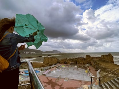 Una mujer trata de abrir su paraguas frente a la playa de Arrigunaga en Getxo (Bizkaia), el pasado 17 de agosto.