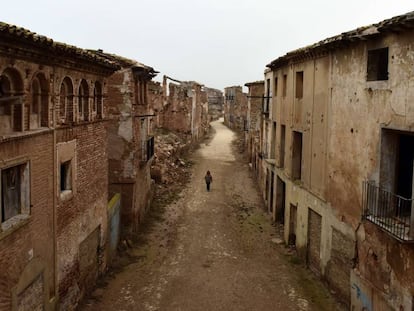 Una guía turística atraviesa una calle desierta en el pueblo abandonado de Belchite, en Aragón.