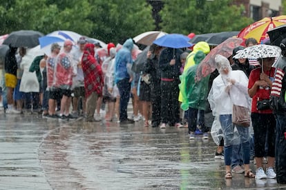 People wait in the rain ahead of a rally for President Donald Trump, Friday, July 7, 2023, in Council Bluffs, Iowa.