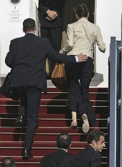 Los escoltas conducen a Bruni y Sarkozy al interior del avión.
