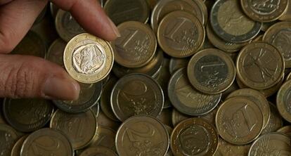 Una persona enseña una moneda de euro.