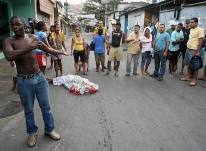 Habitantes del Complejo del Alemán (Río de Janeiro), junto al cadáver de un joven muerto ayer en la operación policial.