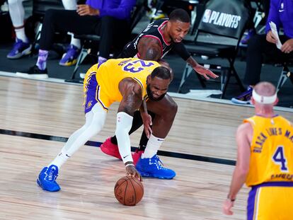 LeBron James protege el balón ante Damian Lillard.