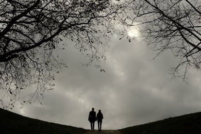 Una pareja pasea bajo un cielo cubierto de nubes, por el parque de la Ciudadela en Pamplona, España.