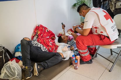 Personal de la Cruz Roja da información a un migrante herido, en Tuxtla Gutiérrez, el 10 de diciembre.