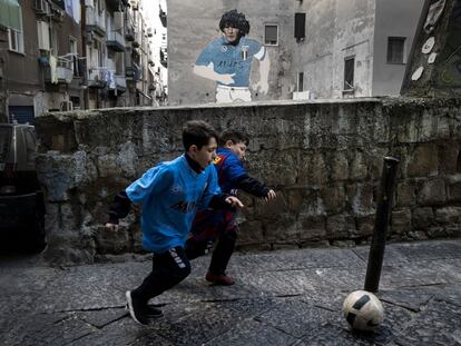 Dos niños, con las camisetas de Maradona y Messi, juegan en el barrio Napolitano de Forcella.