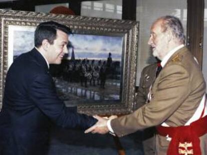 Fotografía facilitada por el pintor catalán Augusto Ferrer Dalmau, en la que aparece él mismo saludando al rey Juan Carlos, en mayo de 2011 ante su cuadro "La gesta de los zapadores", en la Academia de Ingenieros de Hoyo de Manzanares.