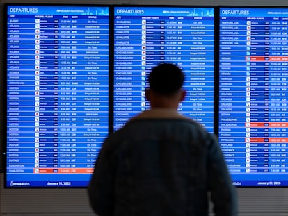 A traveler looks at a flight board with delays and cancellations at Ronald Reagan Washington National Airport in Arlington, Va., Wednesday, Jan. 11, 2023.