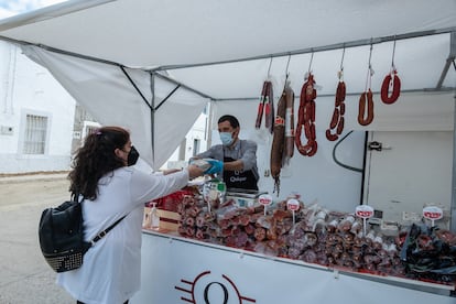 Quique Piris (38) despachando en su puesto de embutidos en el mercadillo de Cedillo.