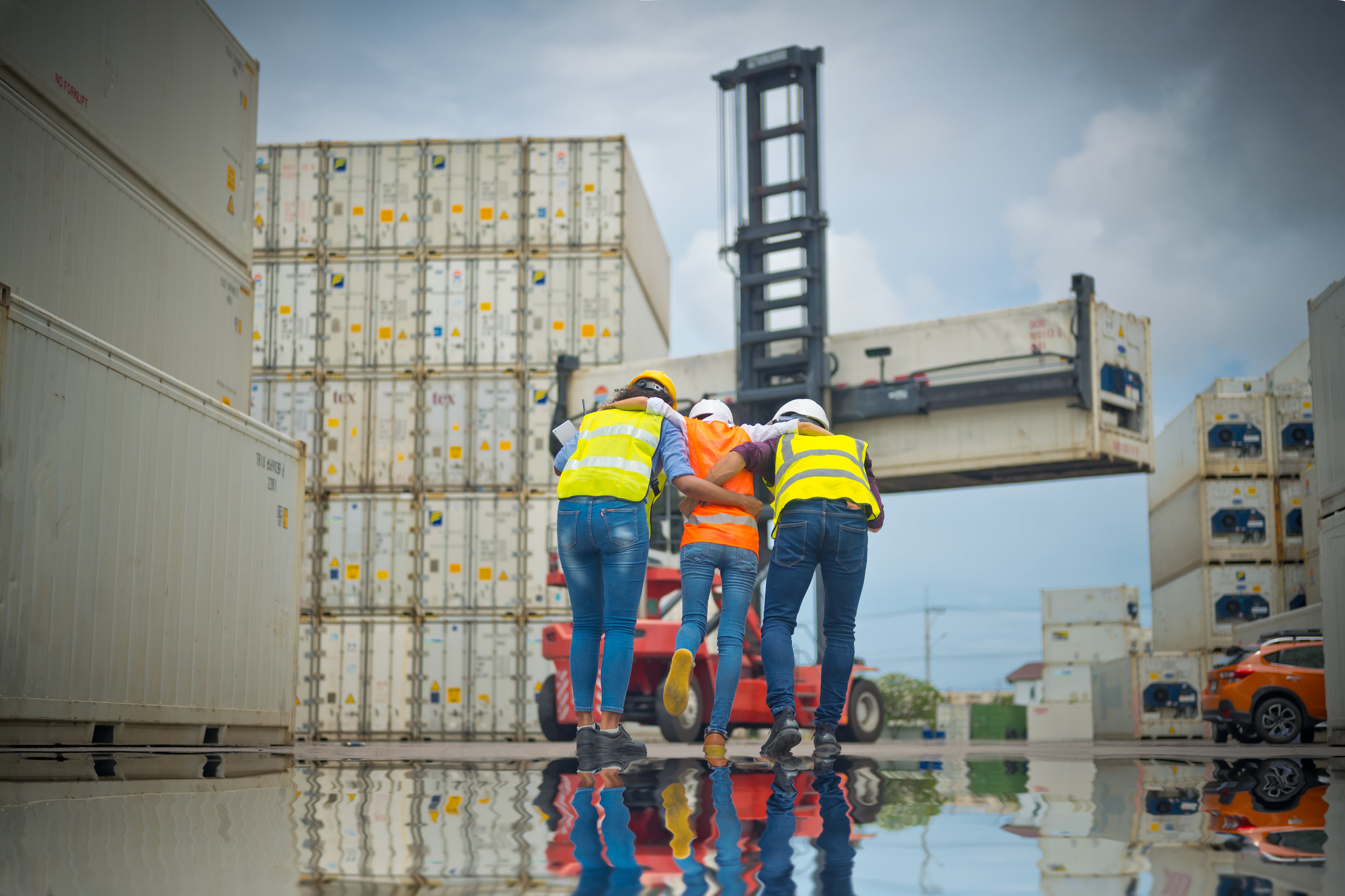 Dos trabajadores ayudan a una compañera que ha sufrido un accidente laboral