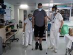 13/07/21 Albert (33 anos) hace ejerciocis de rehabilitacion con la ayuda de Hugo y Angels en el gimnasio de la planta de medicina fisica y rehabilitacion. Este paciente esta en la recta final de su ingreso en el hospital de la Vall dHebron tras ingresar infectado de covid-19 (coronavirus) en la tercera ola de la pandemia y habiendo pasado 100 dias por la UCI. Barcelona, 13 de julio de 2021 [ALBERT GARCIA] 
