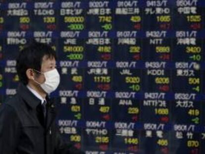 Un viandante pasa delante de una pantalla que muestra información bursátil en Tokio. EFE/Archivo