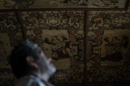 Un hombre observa los cielos historiados de la iglesia de Cocucho.