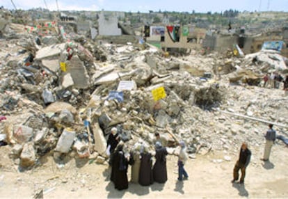 Un grupo de palestinos, ayer ante las ruinas del campo de refugiados de Yenín.