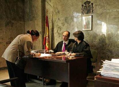 Una inmigrante firma su juramento de fidelidad a la Constitución y al Rey, en el Registro Civil de Madrid