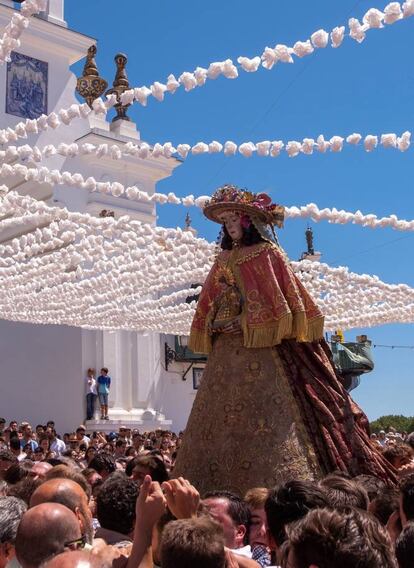 Los almonteños han saltado la reja, dentro del templo, que separa a la Virgen del Rocío de sus fieles a las 14.47 horas, para comenzar la procesión por las calles de la aldea, previa a su traslado a la parroquia de la Asunción de Almonte (Huelva), la conocida como la Venida, que se celebra cada siete años.