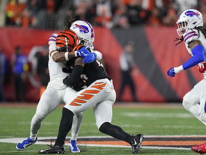 Momento del impacto entre Damar Hamlin (de blanco) y Tee Higgins, de los Bengals (de negro) durante el partido de este lunes.