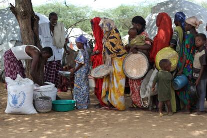 A local aid worker for the UN's World Food Programme delivers food to displaced families in a Mogadishu refugee camp in 2009.