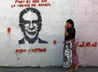 Una indígena pasa frente a una pintada que reclama castigo para el ex presidente Ríos Montt, ayer, en Guatemala