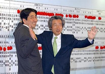 Koizumi y el secretario general del PLD, Shinzo Abe, ponen una rosa en el nombre de cada candidato vencedor.