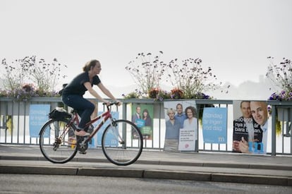 Una ciclista pasa ante carteles electorales de socialdem&oacute;cratas y moderados suecos en Estocolmo.    