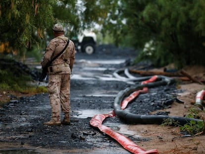 Un soldado hace guardia junto a las mangueras que extraen el agua de la mina de carbón colapsada en Sabinas, Coahuila.