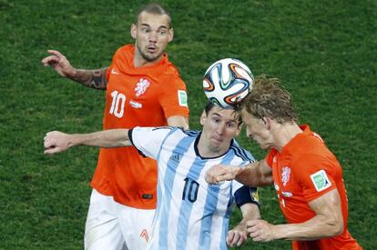 Los jugadores holandeses Wesley Sneijder (i) y Dirk Kuyt (d) tratan de imponerse al capit&aacute;n argentino Lionel Messi. 