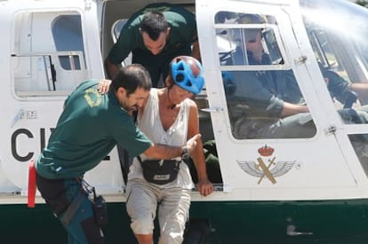 Dutch tourist Mary-Anne Goossens is helped out of the rescue helicopter.