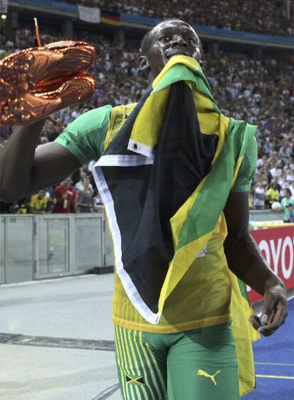 Bolt, con sus zapatillas y la bandera jamaicana.