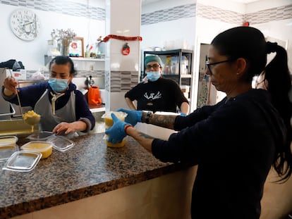 Voluntarios reparten alimentos en el día de Nochebuena, en Málaga.