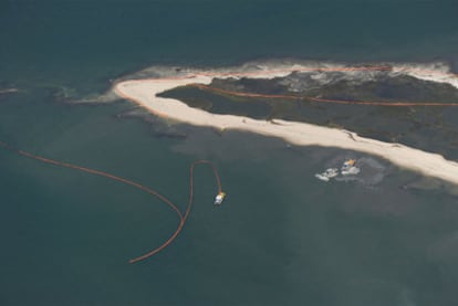 Unos barcos trabajan en la colocación de barreras para frenar la llegada de petróleo a las islas Chandeleur, en Luisiana.