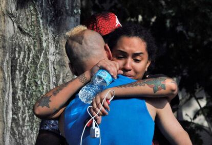Amigos y familiares de los fallecidos se consuelan frente al cuartel general de la policía de Orlando.