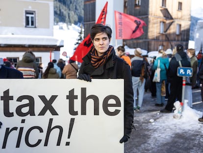 La heredera millonaria y activista social germano-austriaca Marlene Engelhorn sostiene un cartel que dice '¡impongan impuestos a los ricos!' durante la celebración del foro de Davos, el 14 de enero.