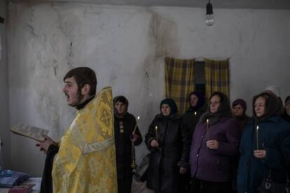El sacerdote Alexander celebra misa en una casa abandonada de Olienivka, después de que su templo fuera ocupado por personas de extrema derecha y entregado a la Iglesia Ortodoxa de Ucrania.