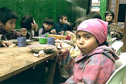 Un grupo de niños, en un comedor popular de una barriada de Buenos Aires.