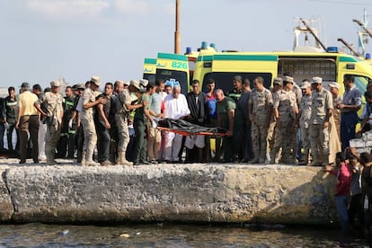 Los equipos de rescate trasladan el cuerpo de una de las v&iacute;ctimas, este jueves en Behera.