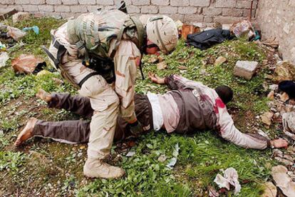 Un soldado de EE UU registra el cuerpo de un insurgente herido en Mosul.