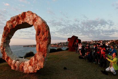 Los turistas fotografían la obra de Peter Lundberg, una de las esculturas expuestas en el paseo marítimo de Bondi, Sidney (Australia).