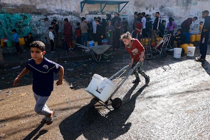 Varios palestinos llenan bidones con agua, este lunes en Rafah. 