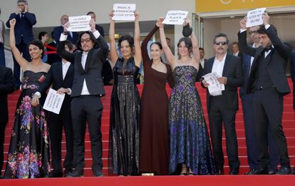 Director Kleber Mendonca Filho (3rdR) and cast members Maeve Jinkings (4thL), Sonia Braga (C) Barbara Colen (2ndL), producer Emilie Lesclaux (4thR) and team hold placards to protest against the impeachment of suspended Brazilian President Dilma Rousseff on the red carpet as they arrive for the screening of  the film "Aquarius" in competition at the 69th Cannes Film Festival in Cannes, France, May 17, 2016.  REUTERS/Jean-Paul Pelissier