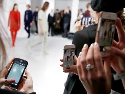 Usuarias utilizando su teléfono móvil en un desfile de moda en Reino Unido.