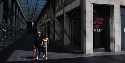 Una pareja pasea por el vacío mercado de Spitalfields en Londres.