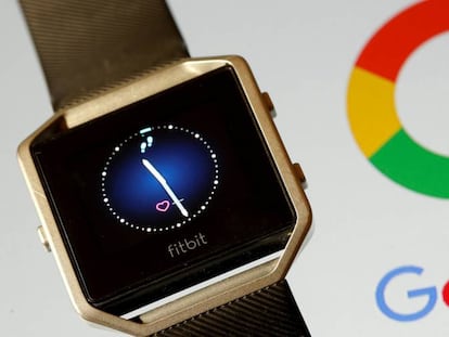 Un reloj inteligente de Fitbit junto a un logo de Google.