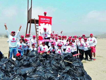 Voluntarios celebrando el Día del Voluntariado MAPFRE en Perú, limpiando una playa.